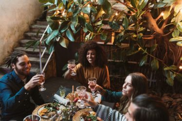 People enjoying a meal outdoors, celebrating with drinks and food.