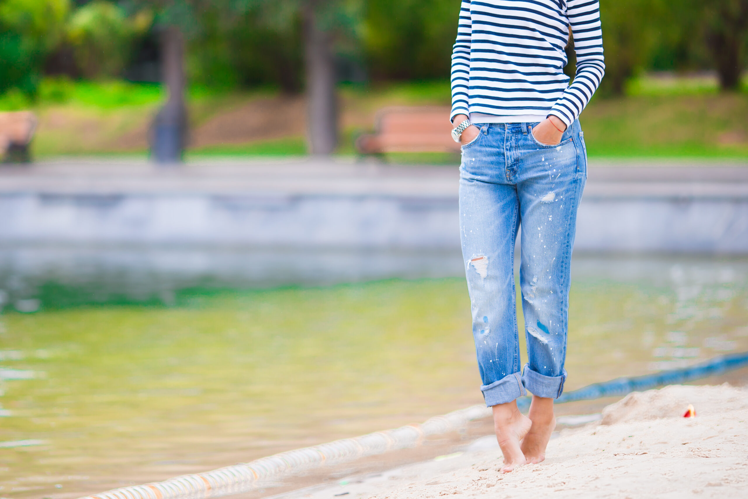 Woman in boyfriend jeans and striped shirt near lake, casual style inspiration