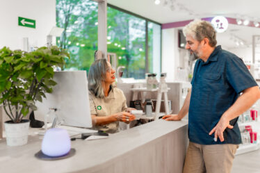 Pharmacist assisting customer with medication and legal considerations after a car accident.