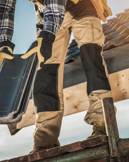 Construction Industry. Roofer with Ceramic Tiles in Hands. Roof Worker Closeup. House Rooftop Covering.